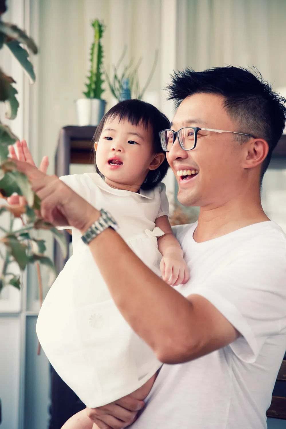 Older and younger sister during a playful indoor family photography moment