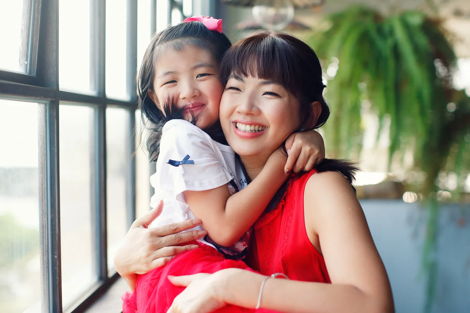 Candid family moment by the window during an indoor Singapore photoshoot