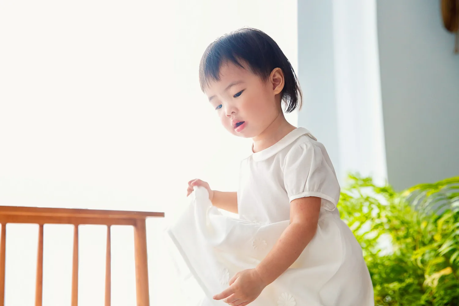 Indoor family photography moment with the two sisters staying close to their parents