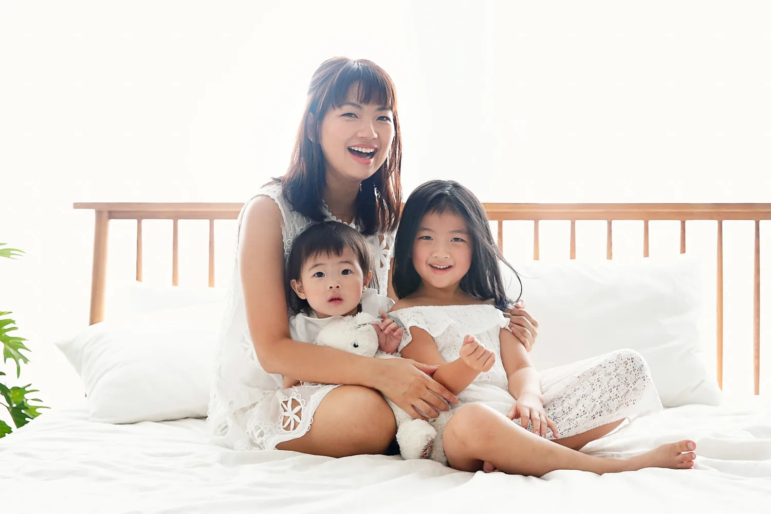 Warm home-session portrait of Angela and Andrew with their daughters in Singapore