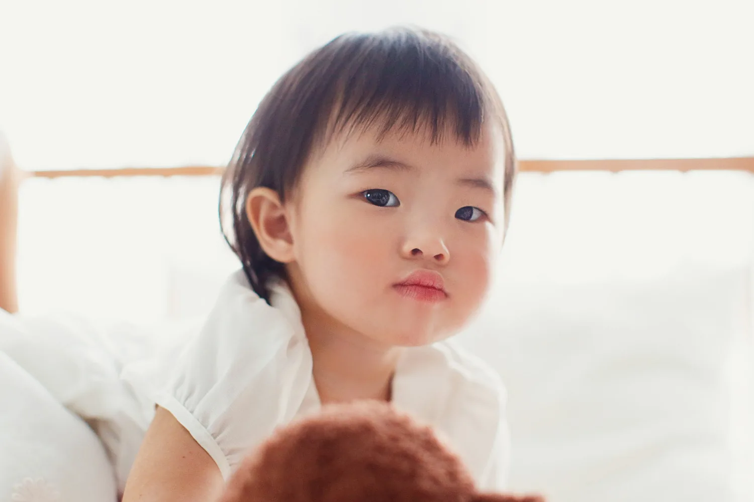 Sisters sharing a quiet indoor moment during a Singapore family session