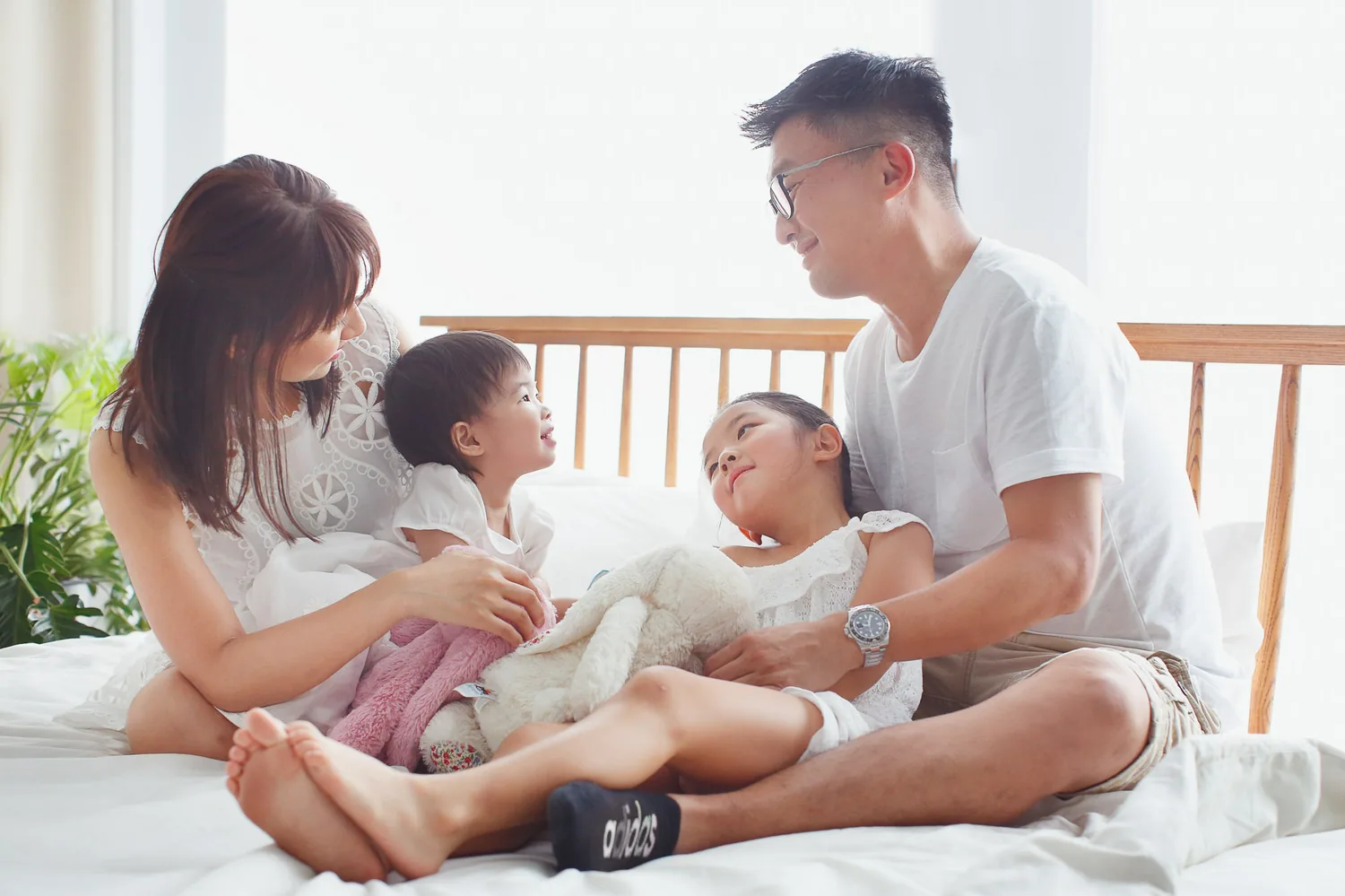 Angela and Andrew laughing with their daughters during a relaxed home photoshoot
