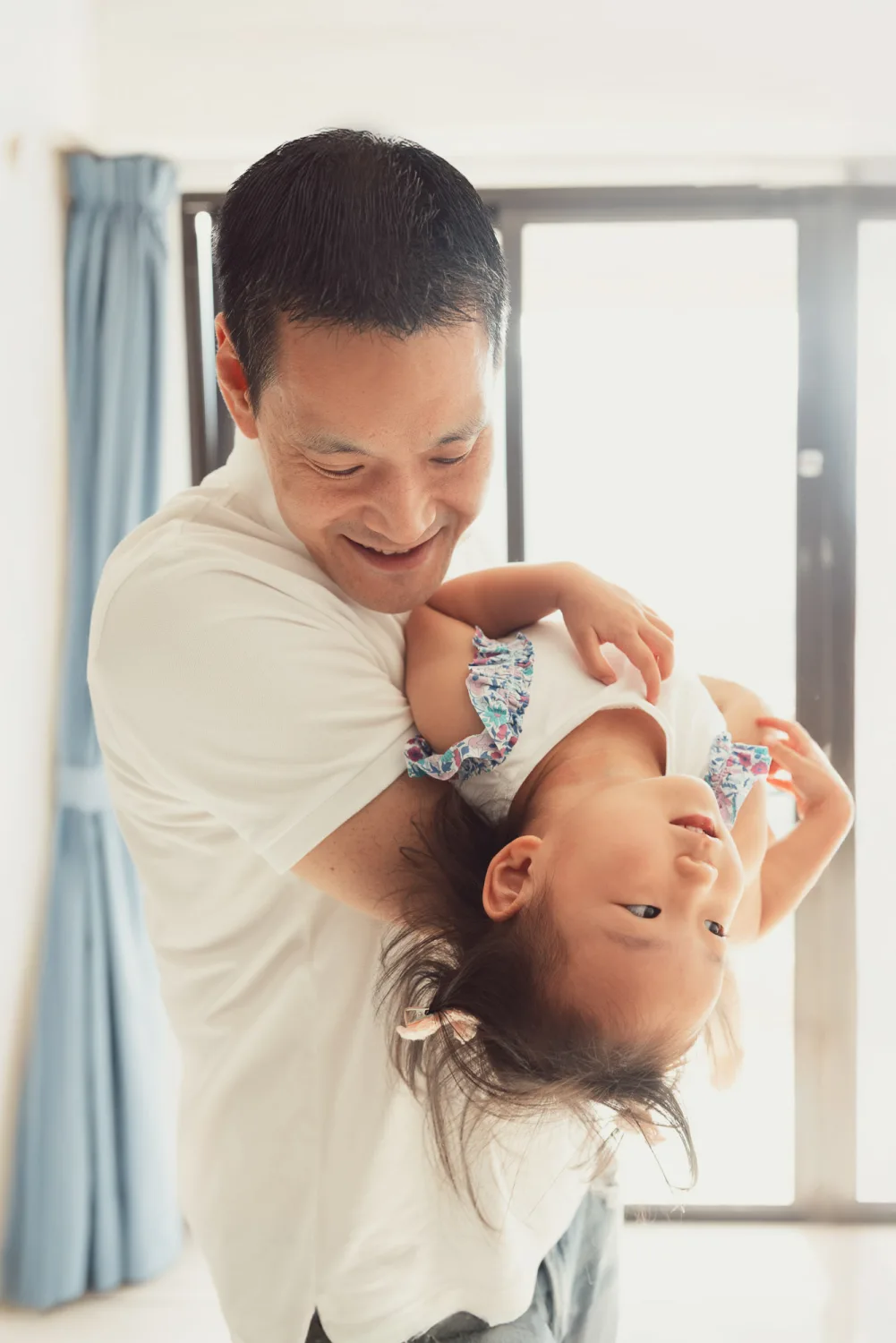 Andrew playing upside down with Amelia indoors
