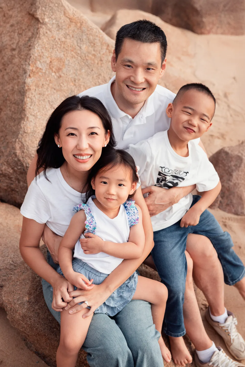 Chelsea, Andrew, Nathan and Amelia together on the rocks at the beach