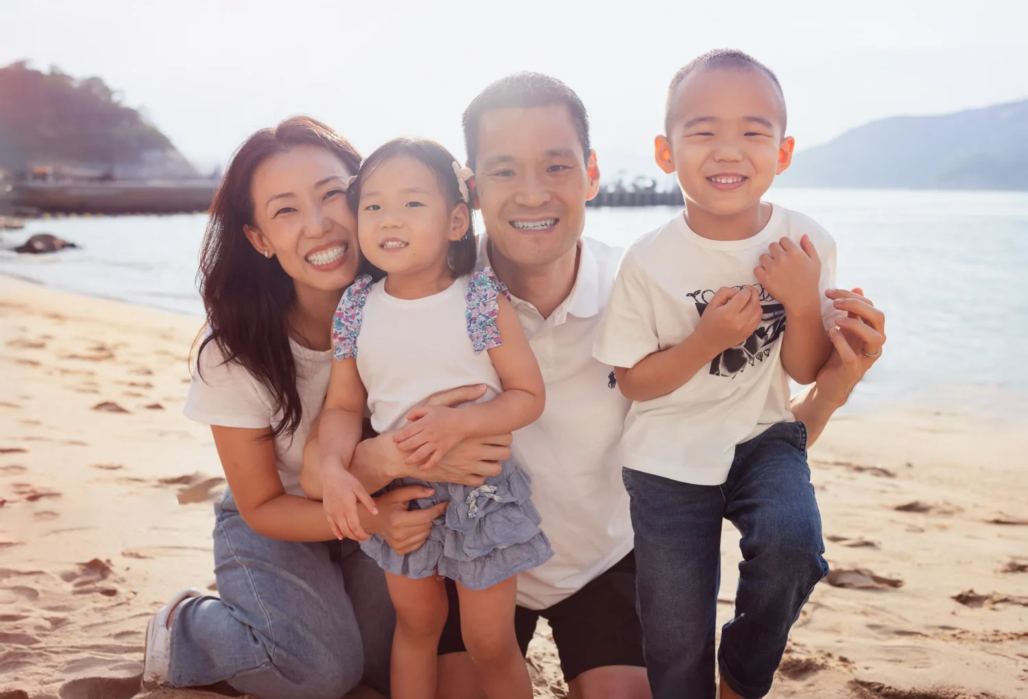 Chelsea and Andrew with Nathan and Amelia smiling together on the beach