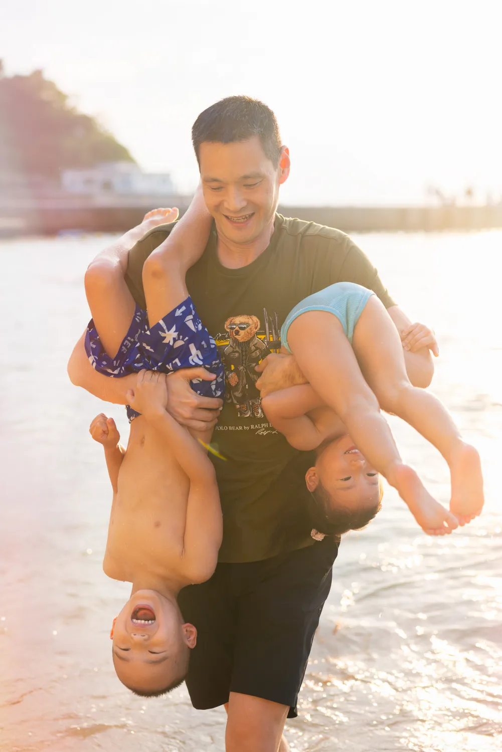 Andrew playing upside down with Nathan and Amelia in the water