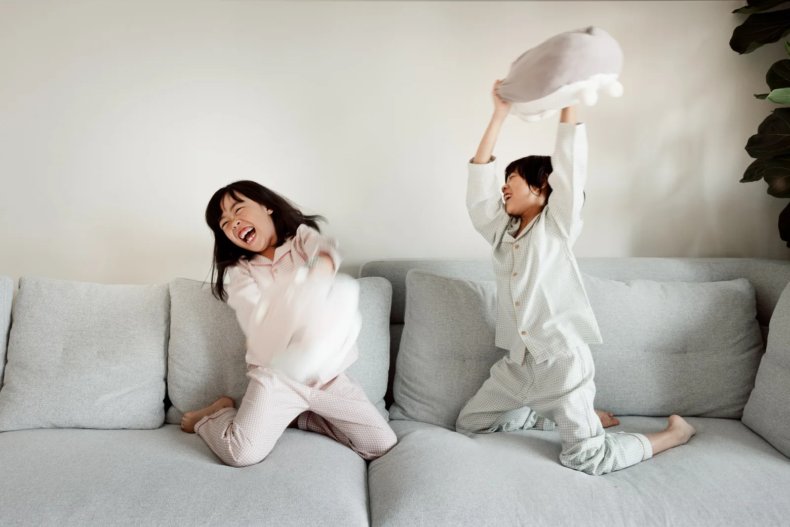 Girls in matching pyjamas laughing during relaxed Singapore family session
