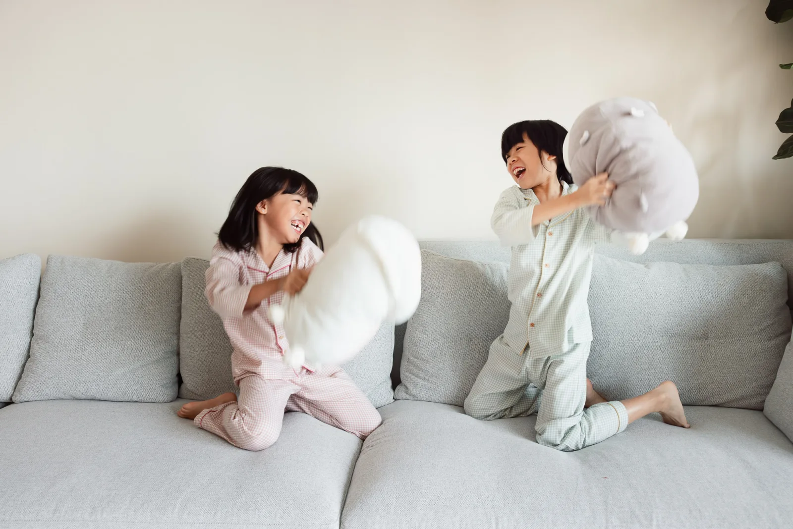 Family in pyjamas cuddling together on the bed during indoor shoot