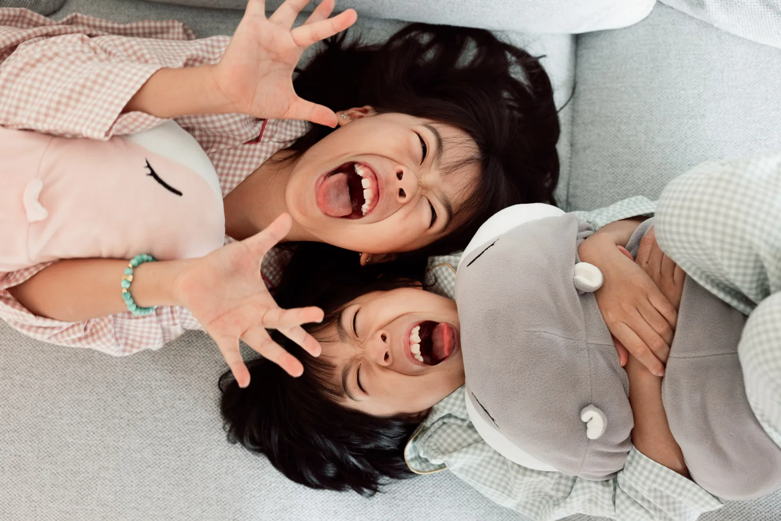 Daughters jumping on the bed in pyjamas during fun family photography session