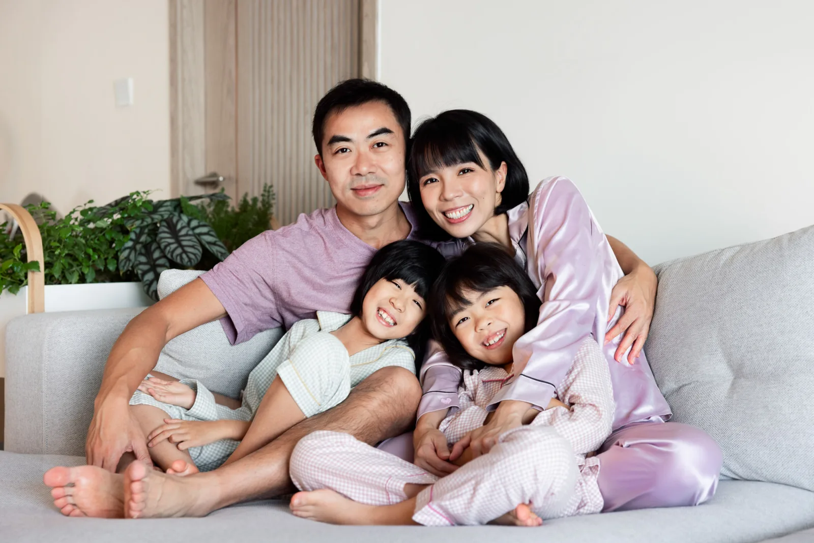 Family pillow fight in pyjamas during indoor photography session