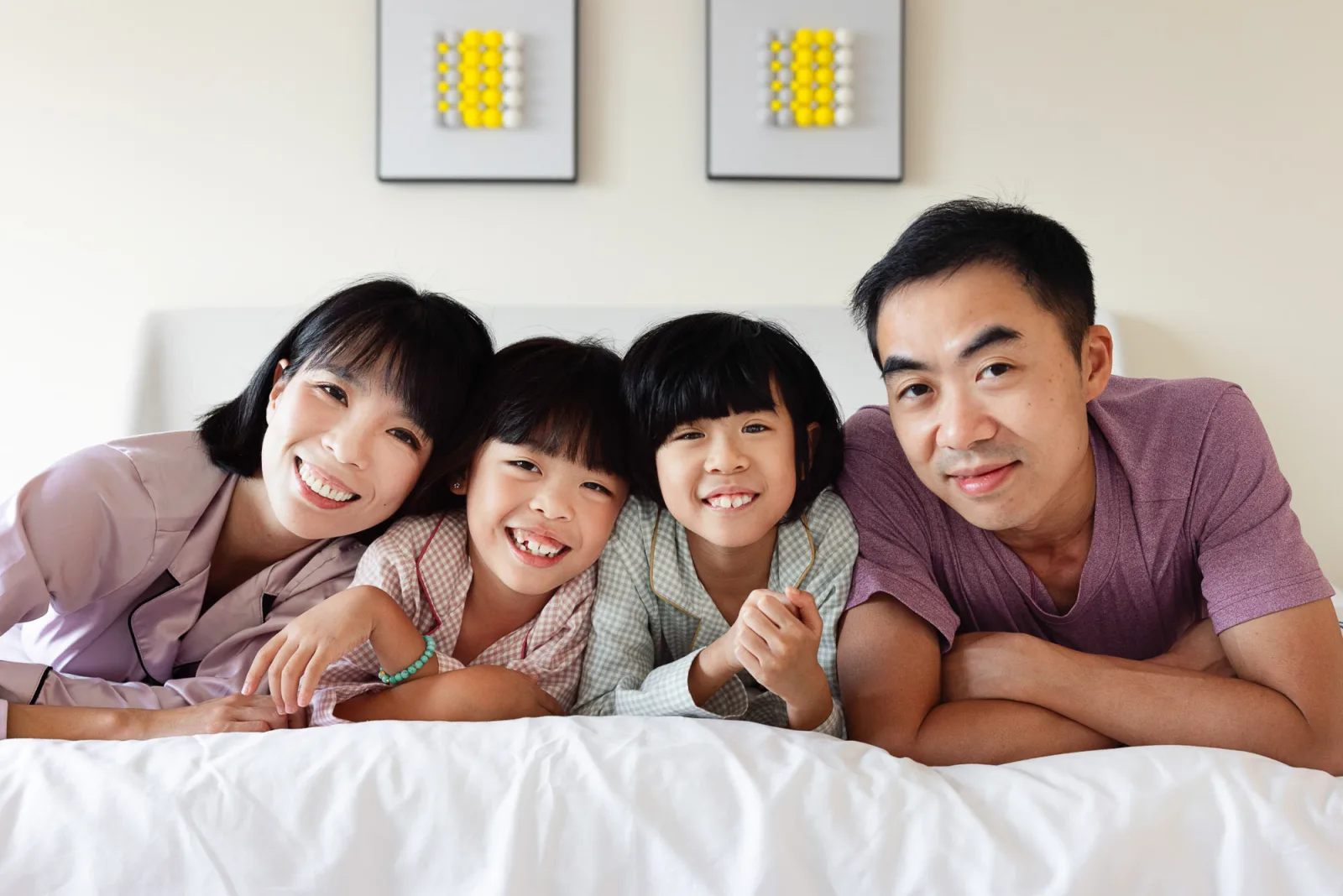 Family resting together after pillow fight during indoor photography session