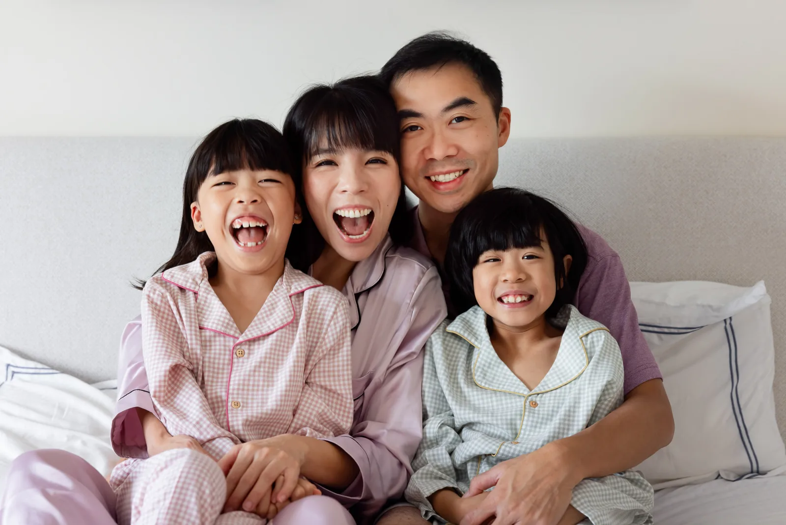 Sisters cuddling in pyjamas during quiet moment after pillow fight