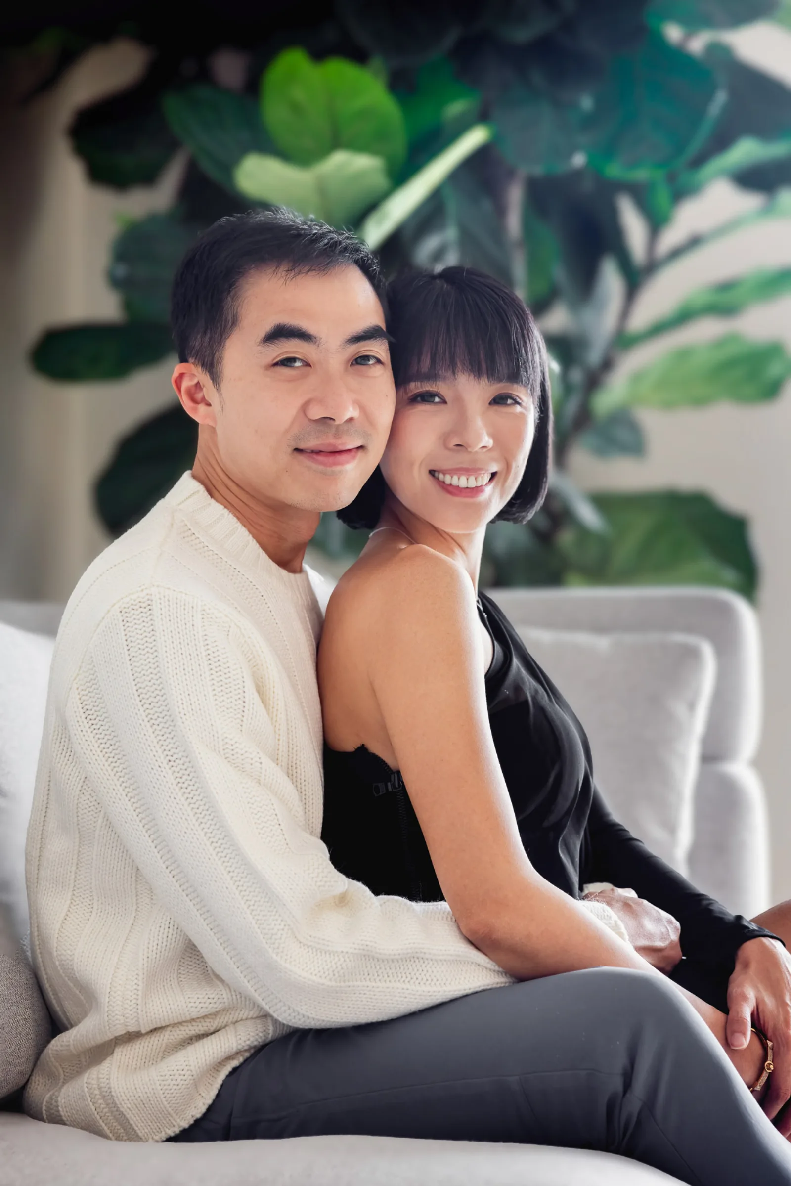 Family of four in coordinated outfits with soft natural indoor lighting