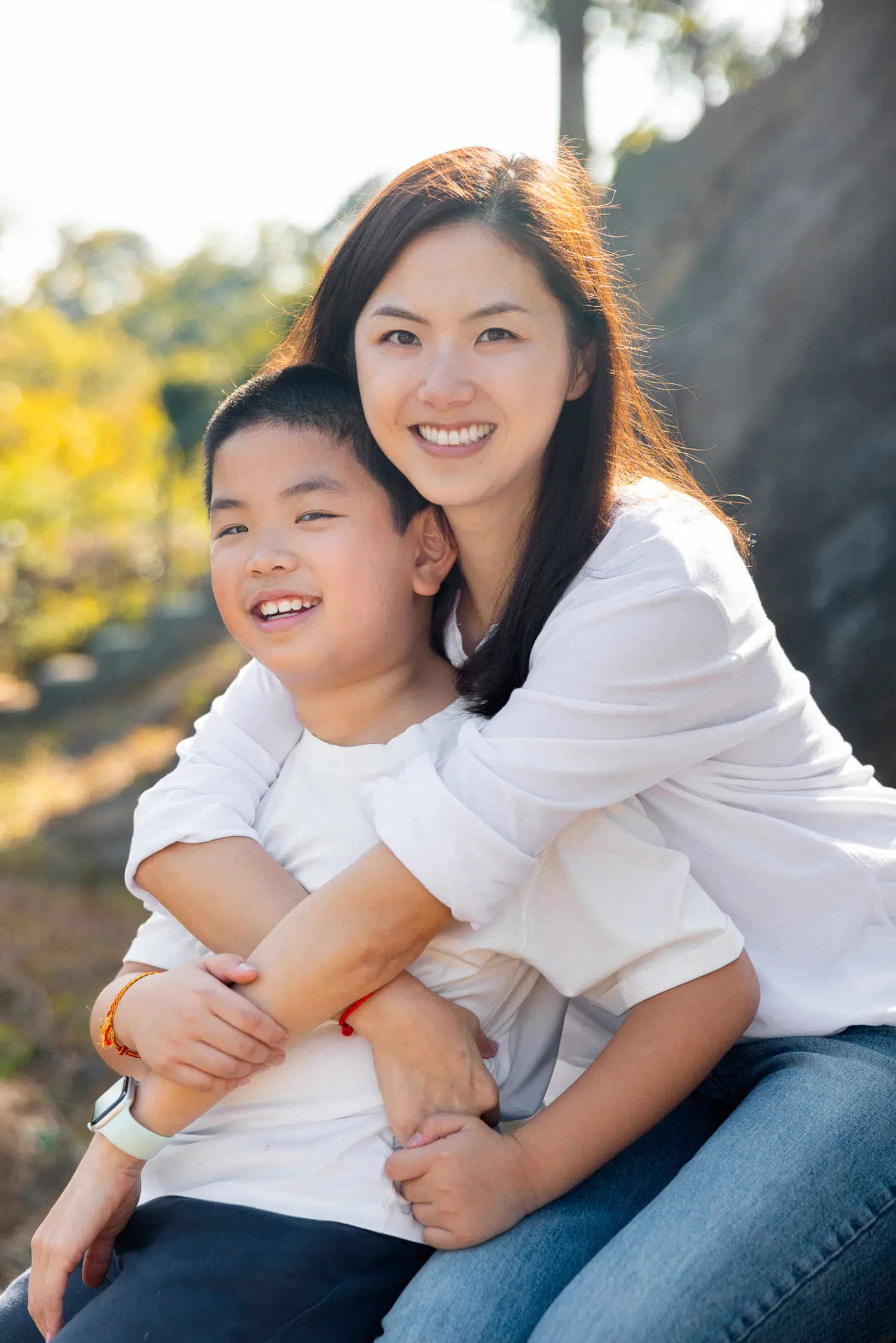 Xenia embracing Lachlan on the nature trail, mother and son in warm sunlight