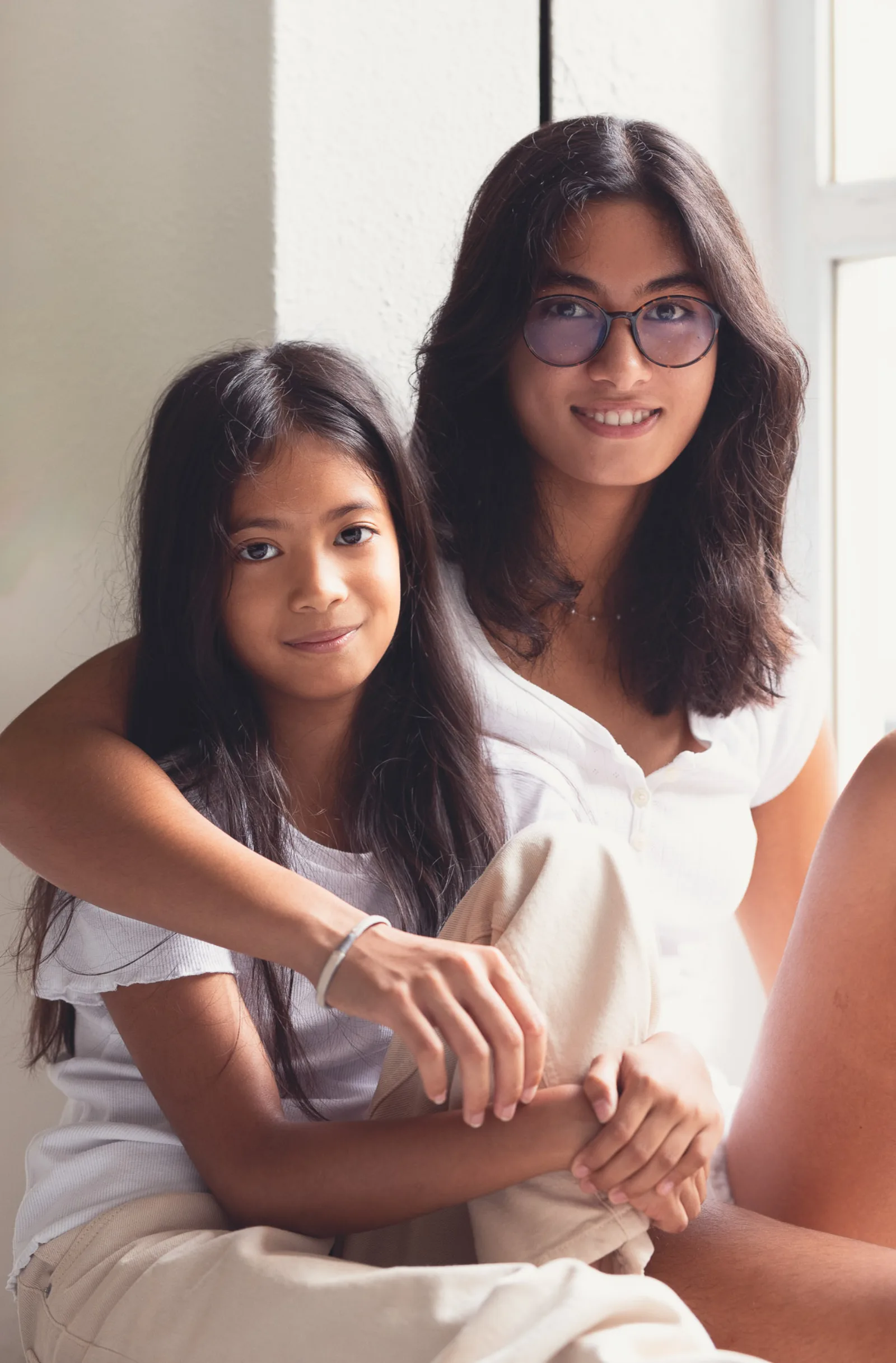 Father lifting his youngest child while older siblings watch and laugh