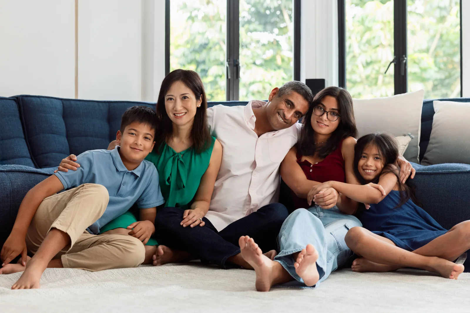 Intimate family cuddle on the sofa during golden hour window light