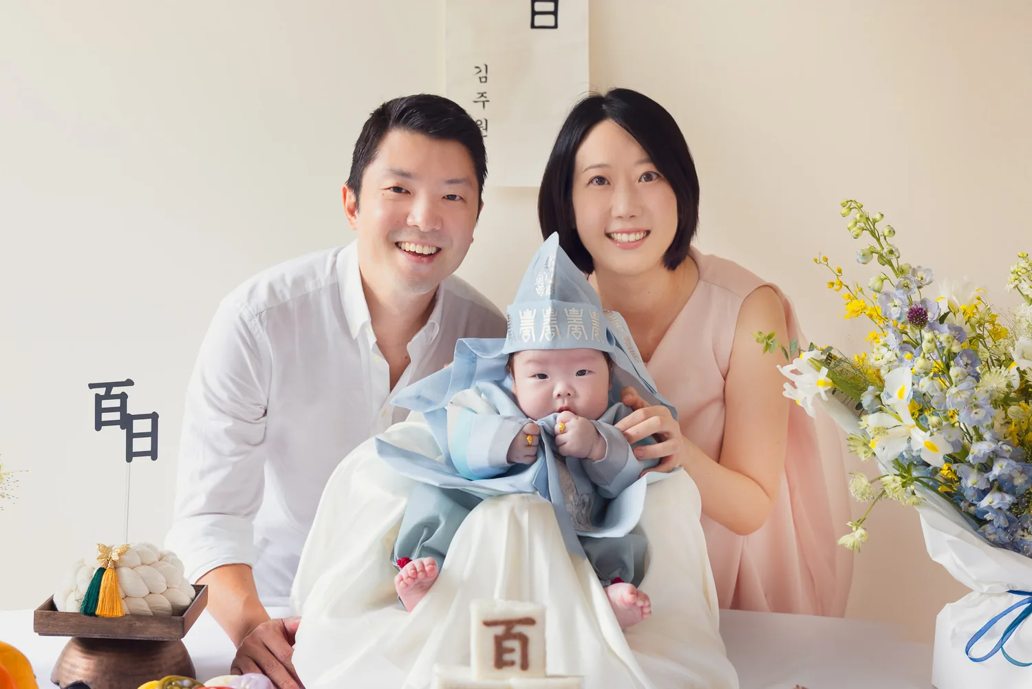 Ji, Kristin and Juwon seated at home for a Korean baek-il 100-day family photoshoot in Singapore