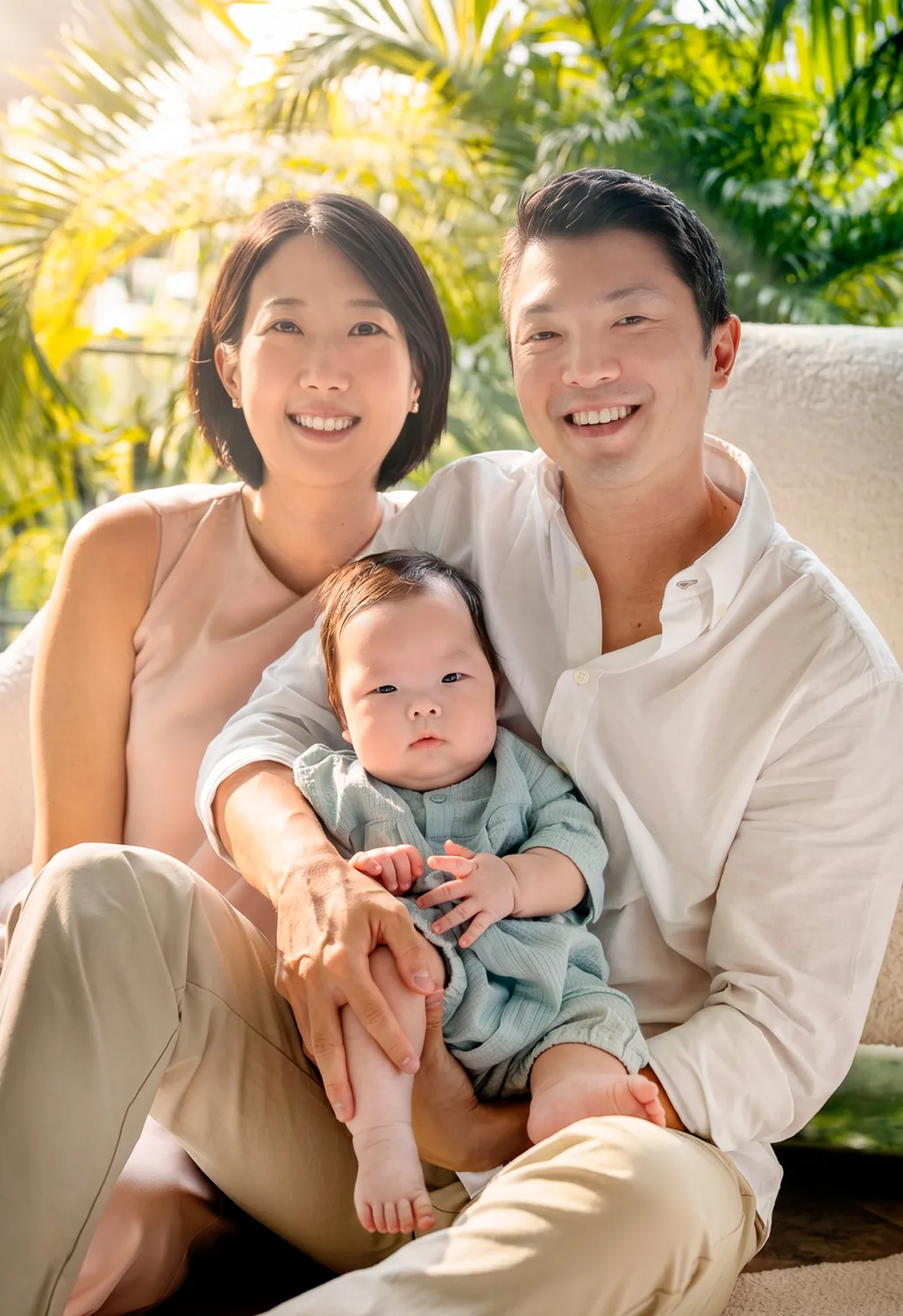 Ji, Kristin and Juwon sitting together in soft window light during a Singapore family session