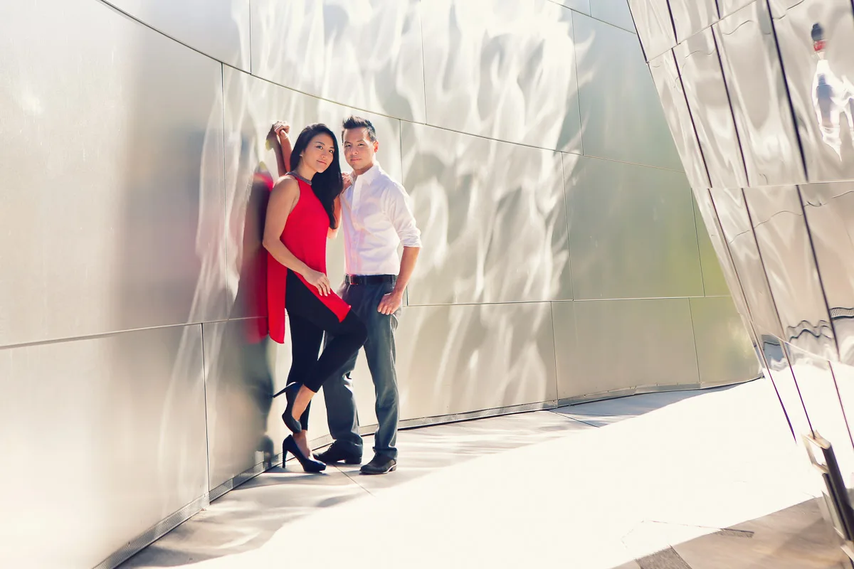 Julie and James standing close beside a reflective wall during their engagement shoot