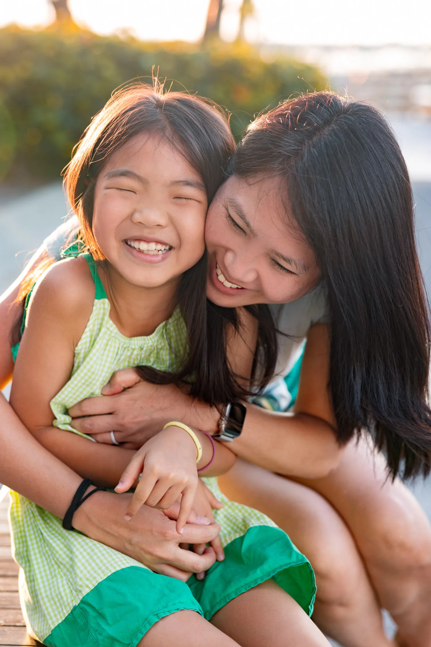 Sharon and Mirei sharing a joyful embrace in golden hour light