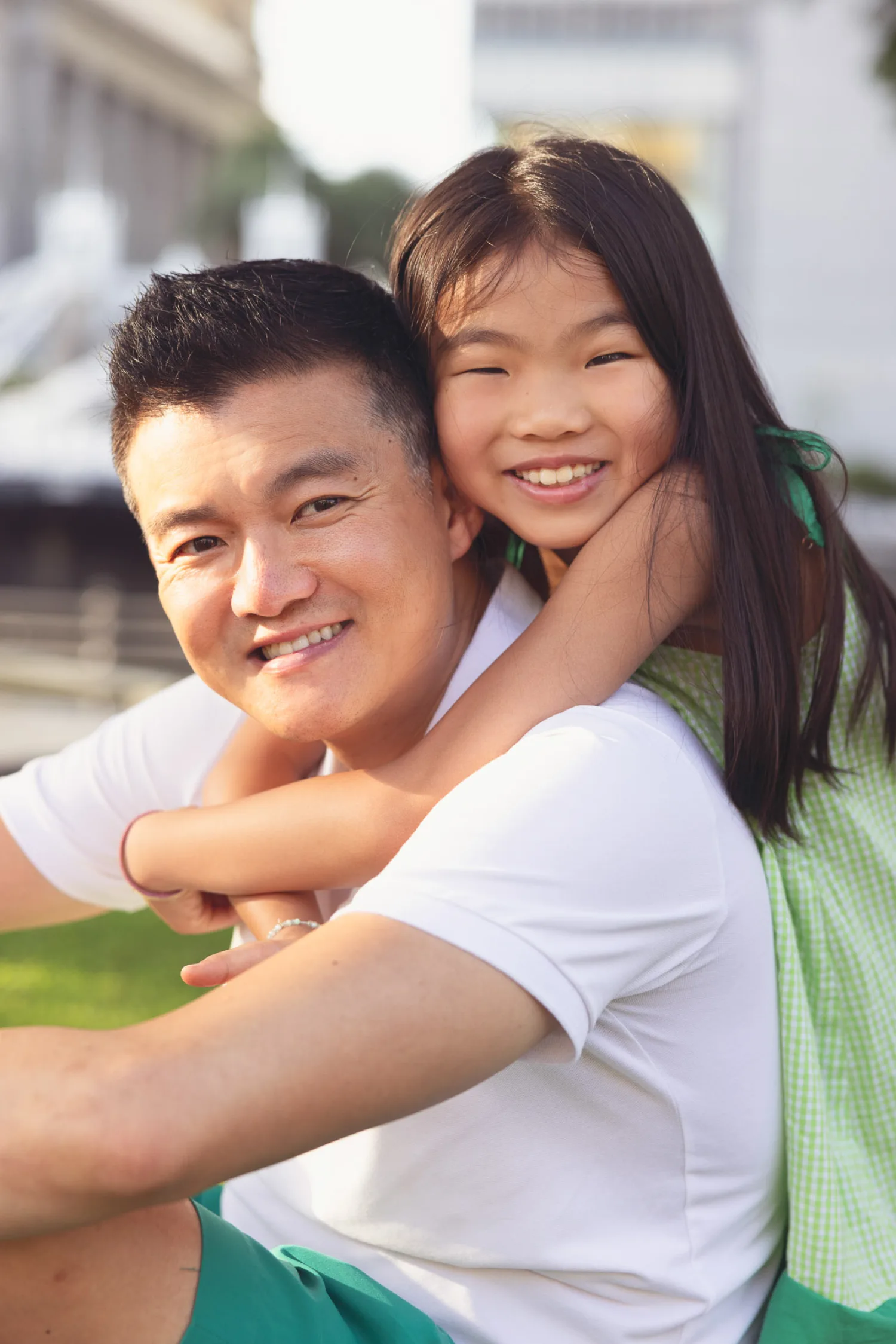 Casey and Mirei sharing a big hug on the grass near Marina Bay