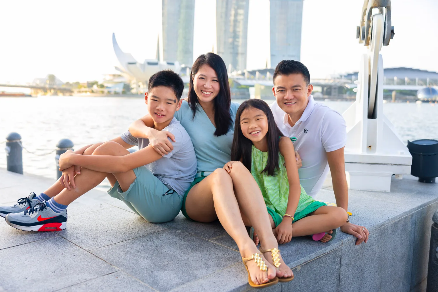 Casey, Sharon, Avery, and Mirei seated at Marina Bay with the iconic Marina Bay Sands behind them