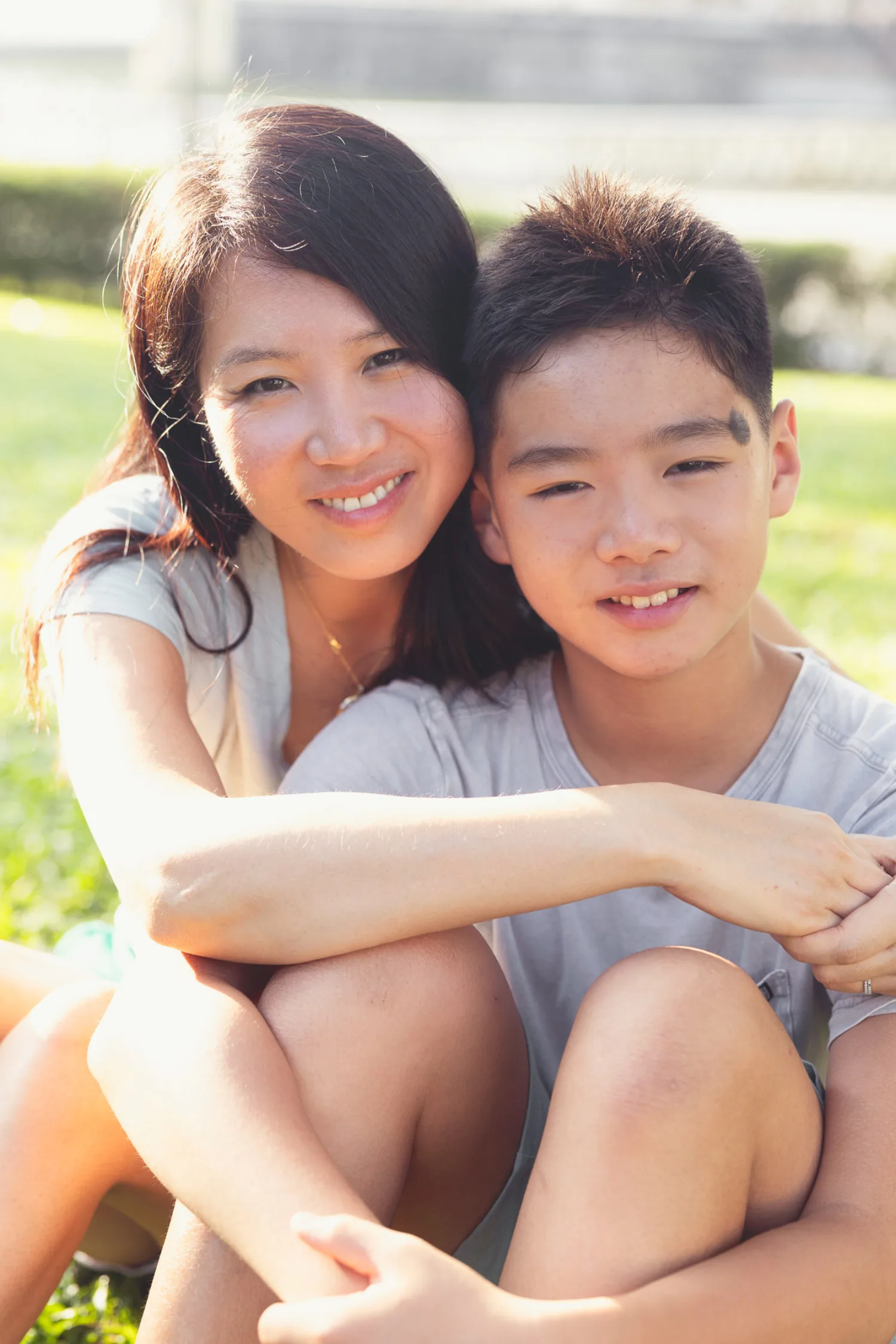 Sharon and Avery sitting close on the grass, smiling warmly
