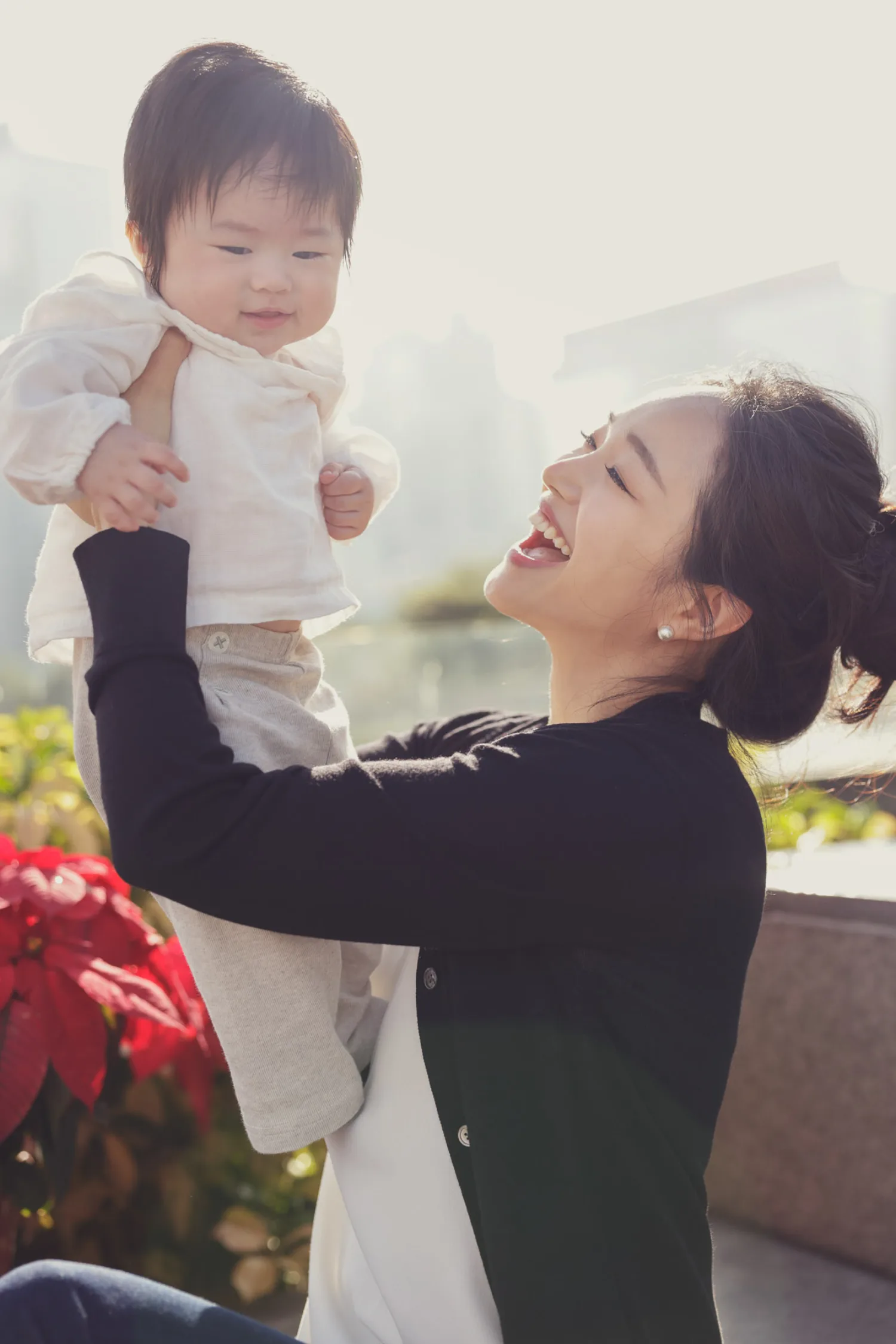 Mother holding baby outdoors during golden hour newborn session