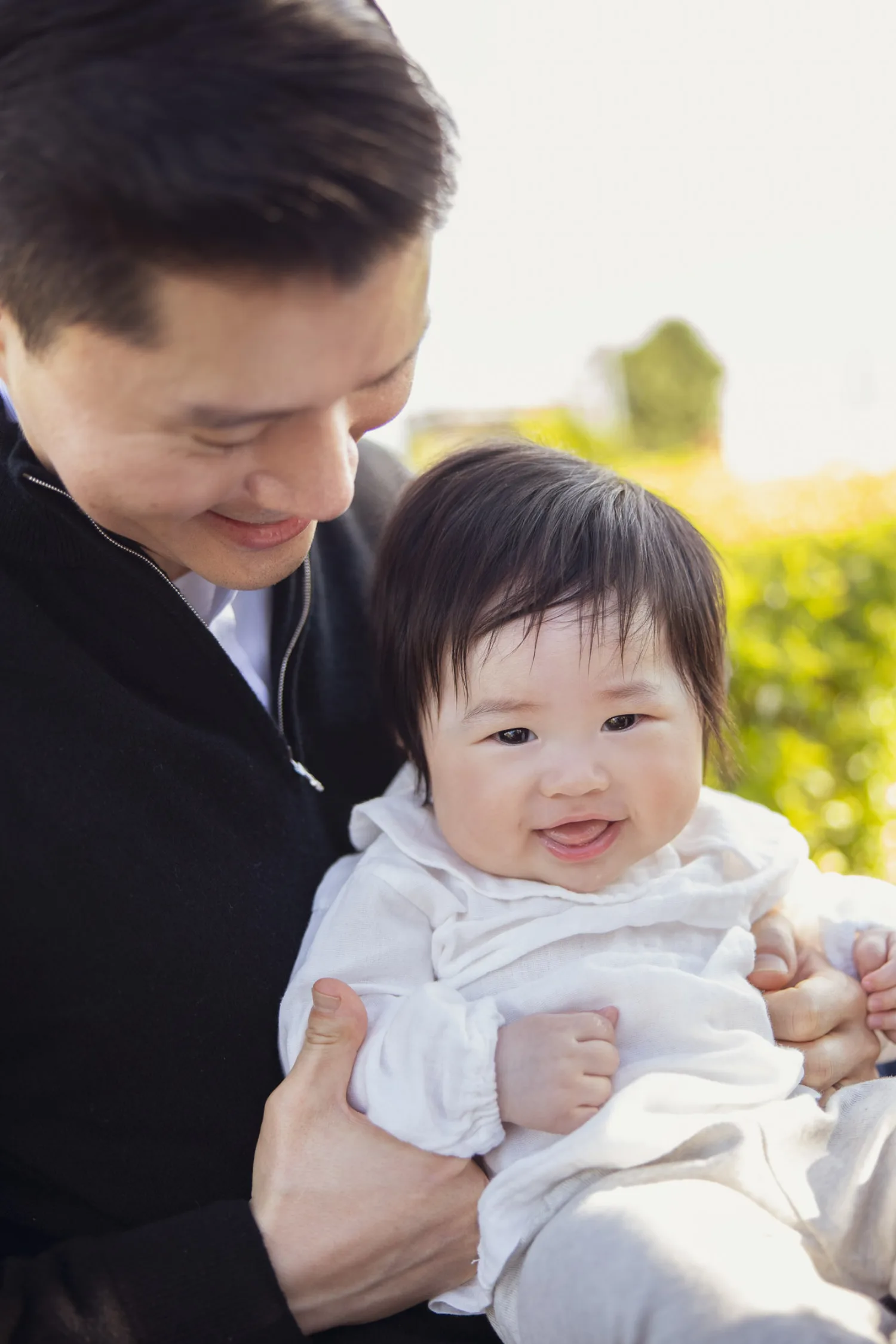 Family enjoying outdoor newborn photoshoot in golden light