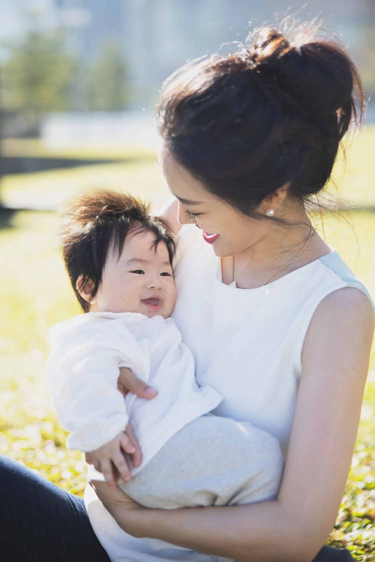 Tender outdoor portrait of Paul and Danbi with their newborn in Singapore