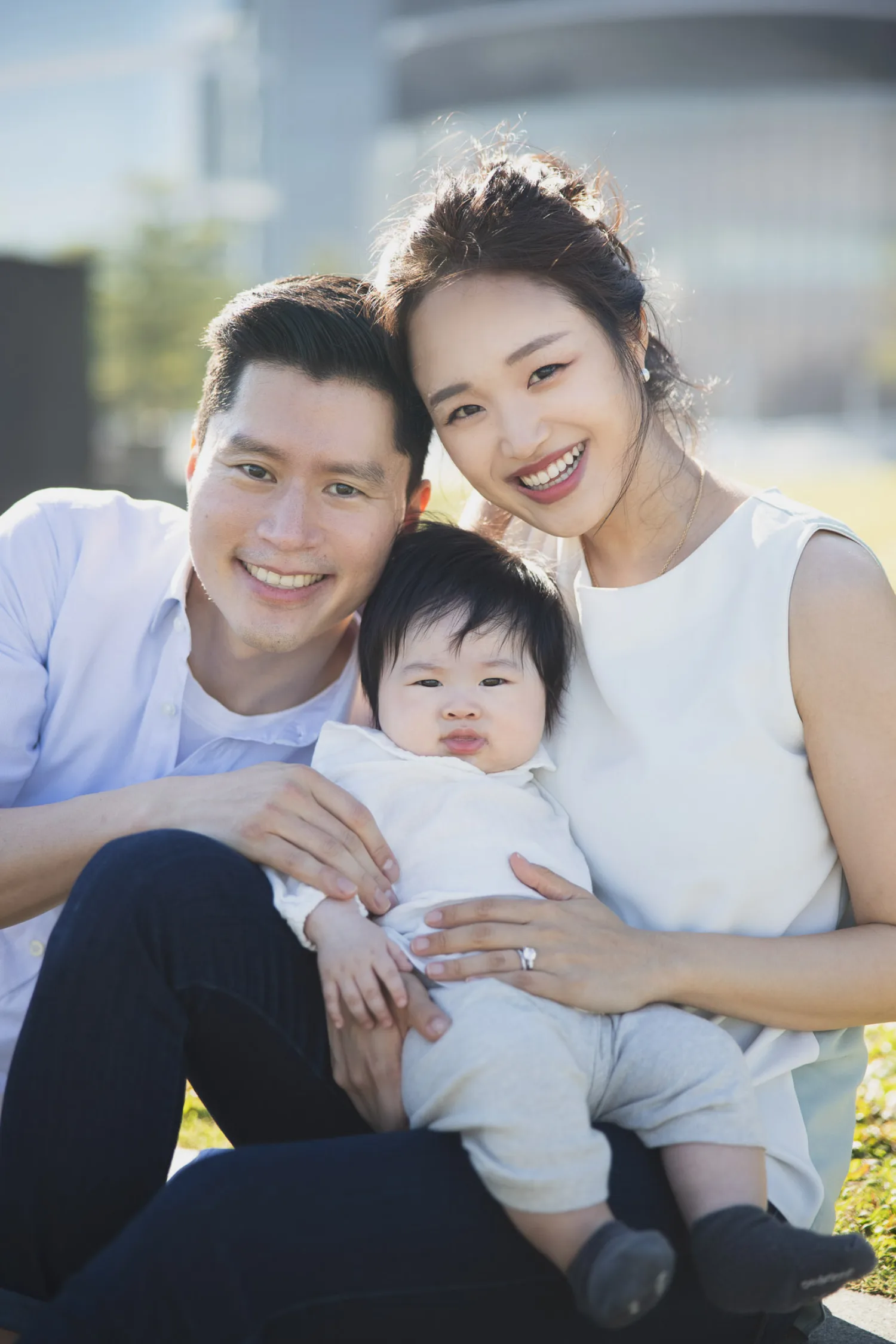 Joyful family of three walking together during outdoor newborn session