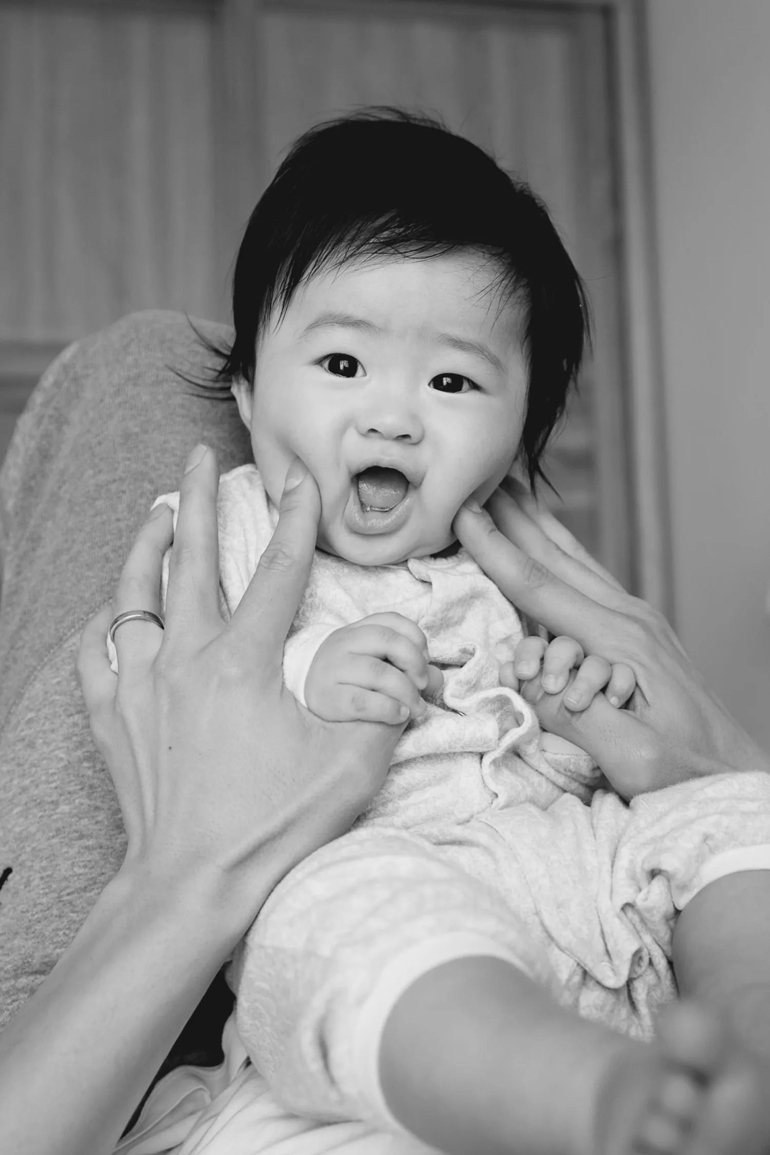 Black and white photograph capturing a pure moment between parents and newborn