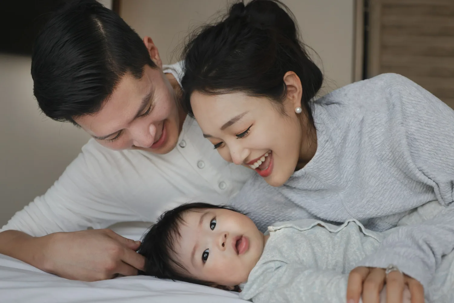 Paul and Danbi with their newborn baby during an indoor family portrait session in Singapore
