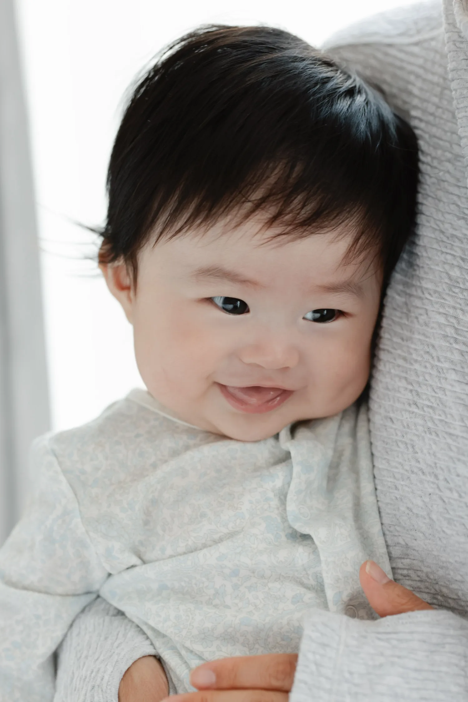 Loving mother holding newborn close during intimate home session in Singapore