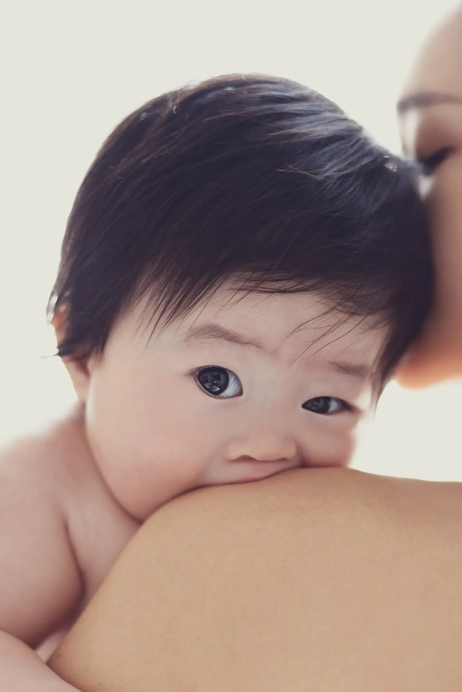 Adorable newborn baby with wide curious eyes during indoor portrait session