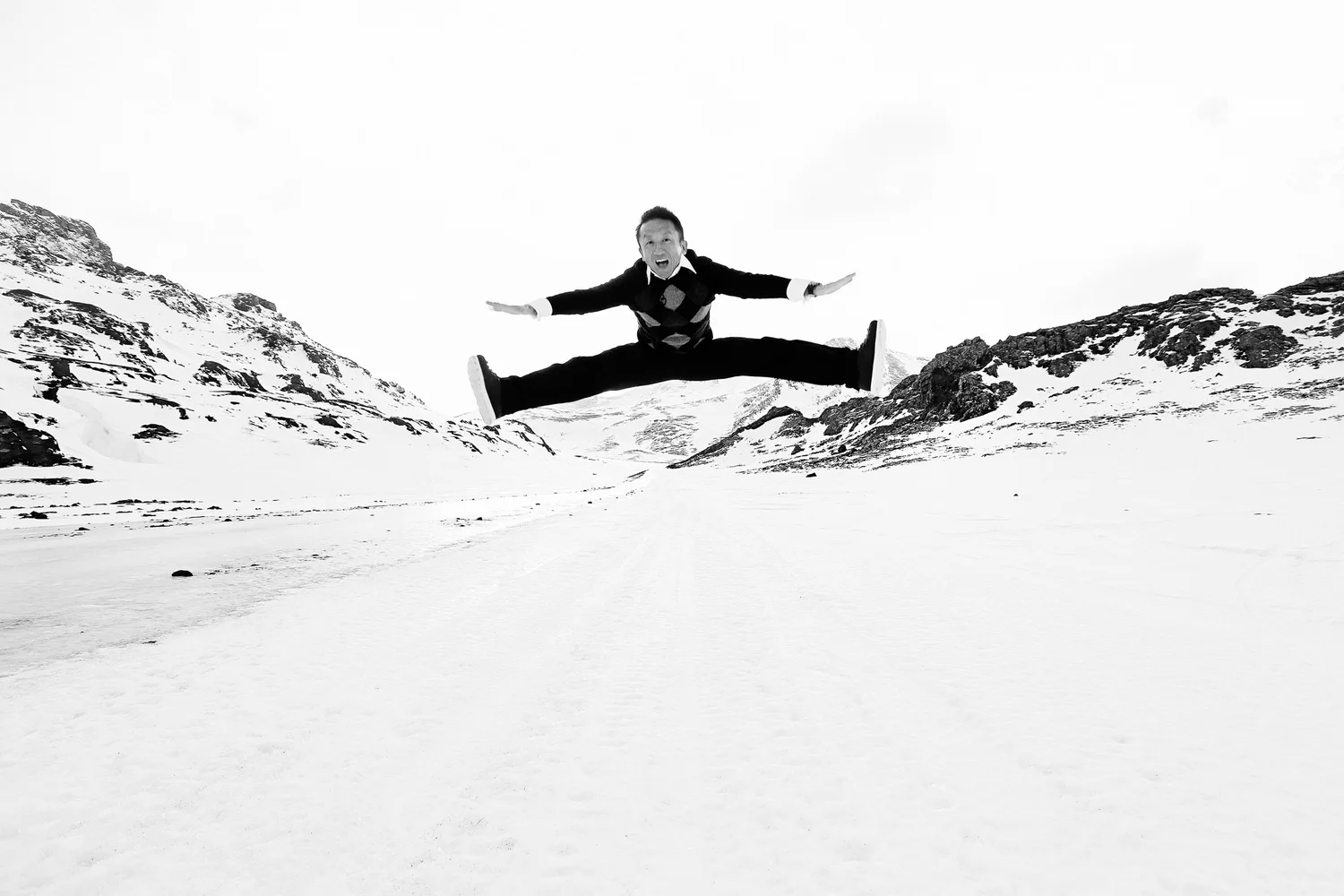 Derek jumping in a suit across Iceland's snowy landscape during the engagement trip