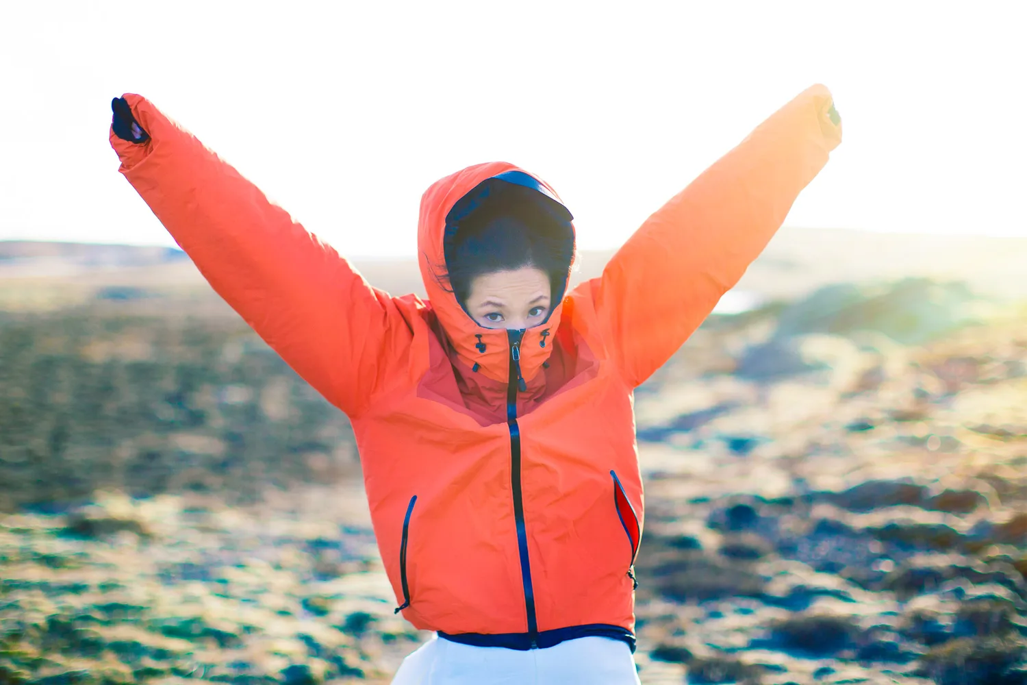 A bundled figure celebrating in Iceland's cold hillside light