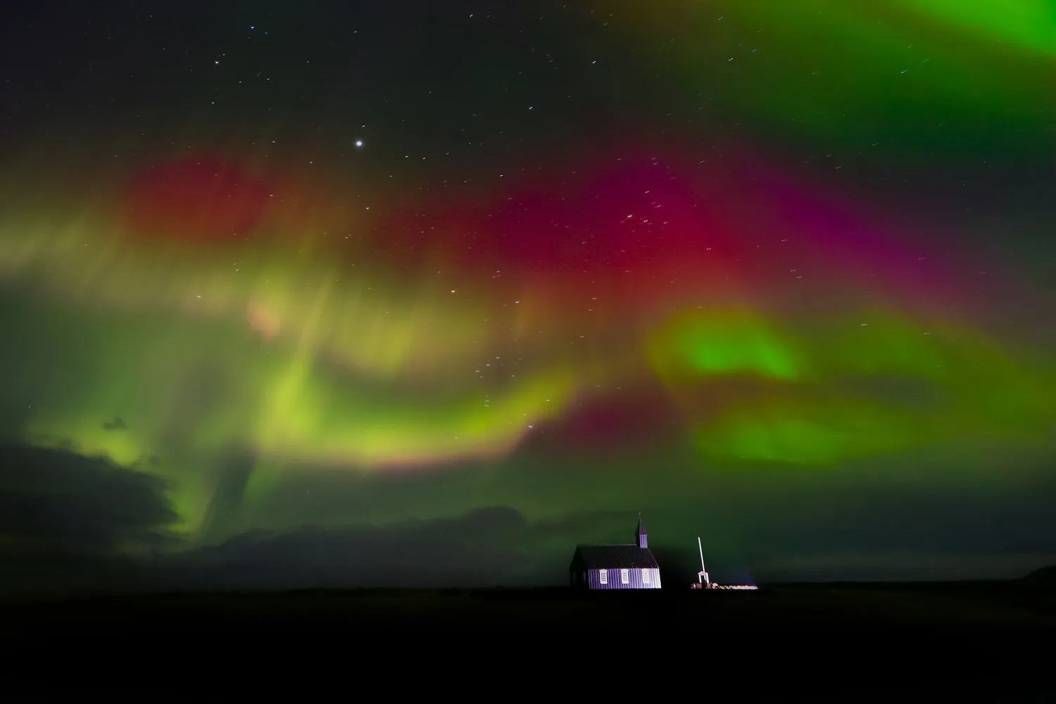 Aurora borealis over the church where Desiree and Derek will be getting married in Iceland