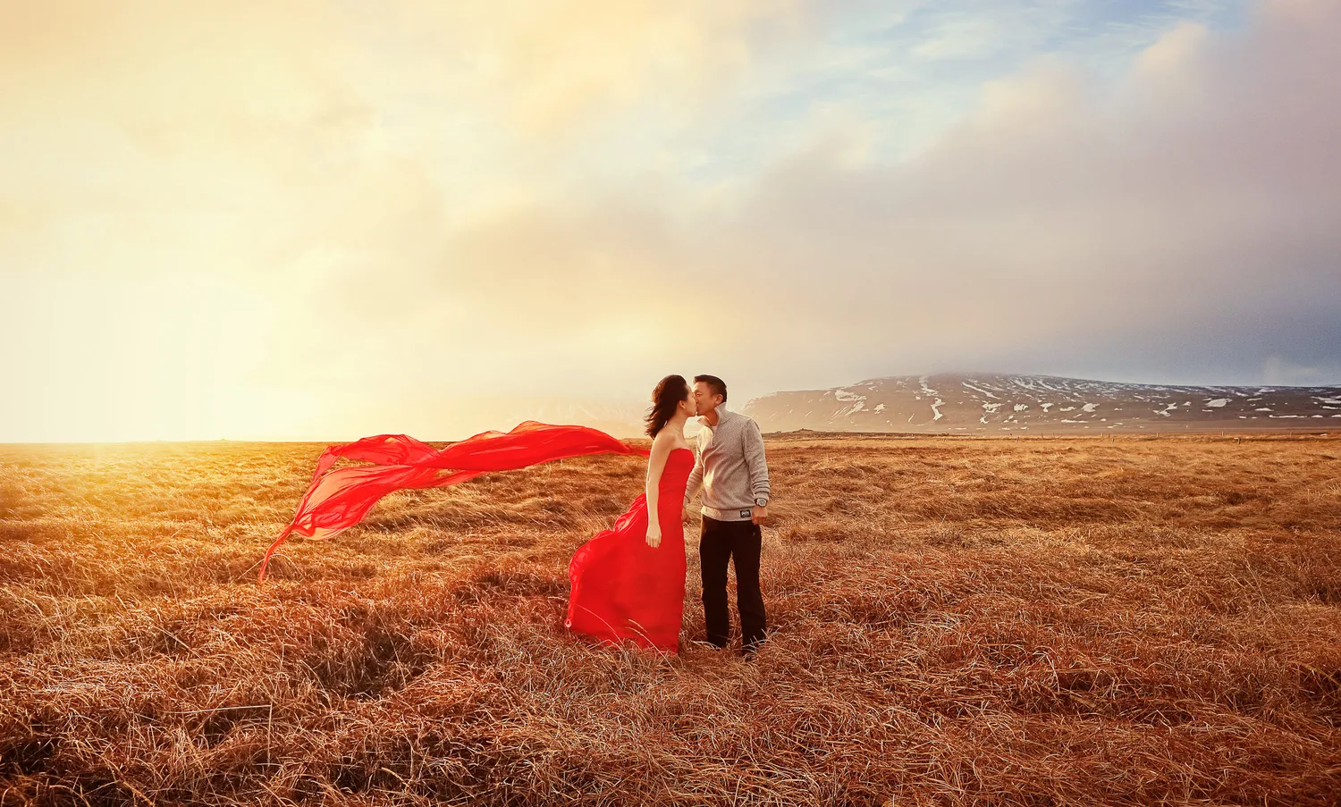 Desiree and Derek kissing in an open Iceland field during their engagement session