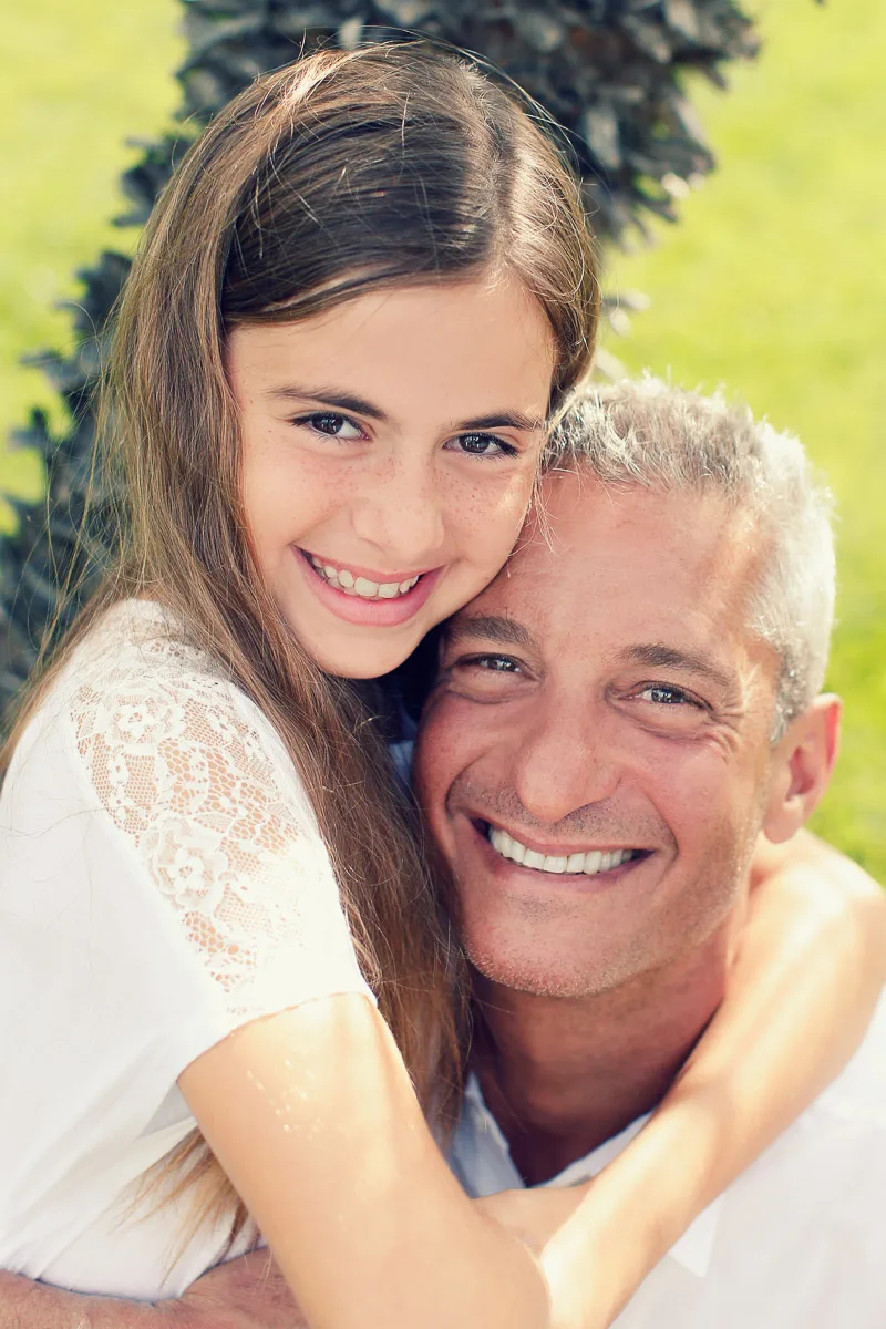 Hannah hugging Rob from behind during a relaxed garden portrait