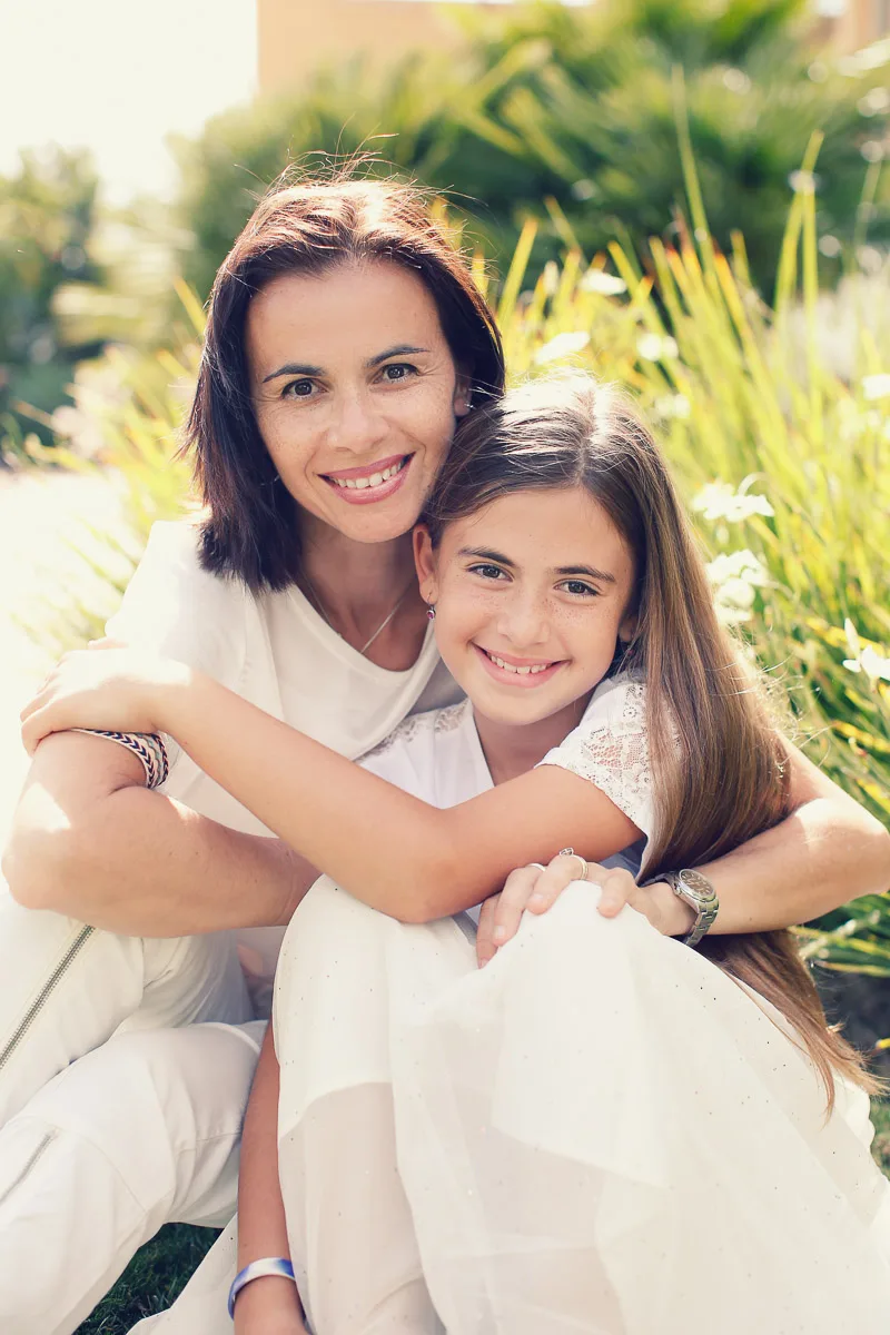 Clara and Hannah sitting close together in soft garden light
