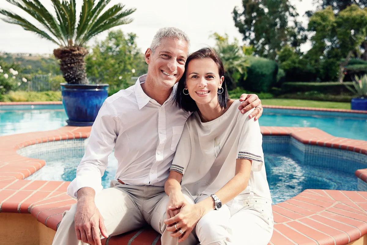 Rob and Clara sitting together beside the pool during their at-home family session