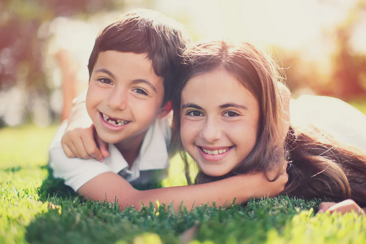 Jess and Hannah lying together on the grass during their family photoshoot at home