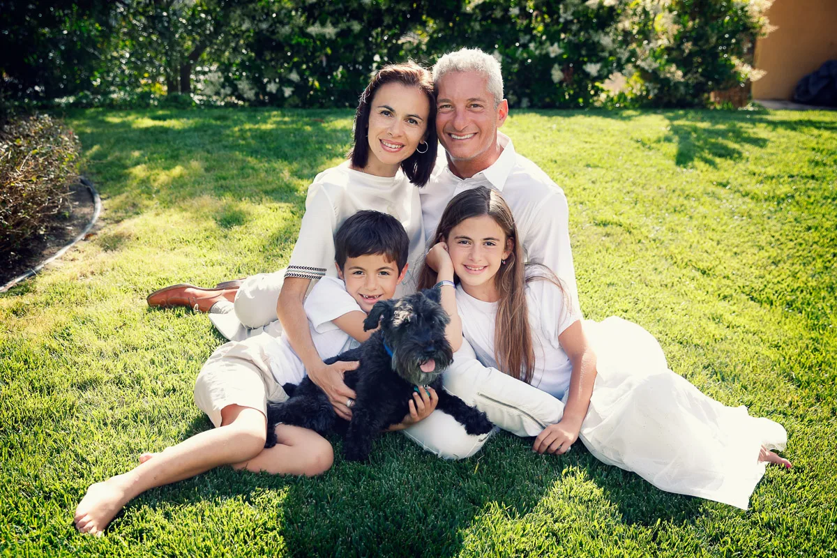 Rob, Clara, Jess and Hannah sitting together on the lawn with their dog
