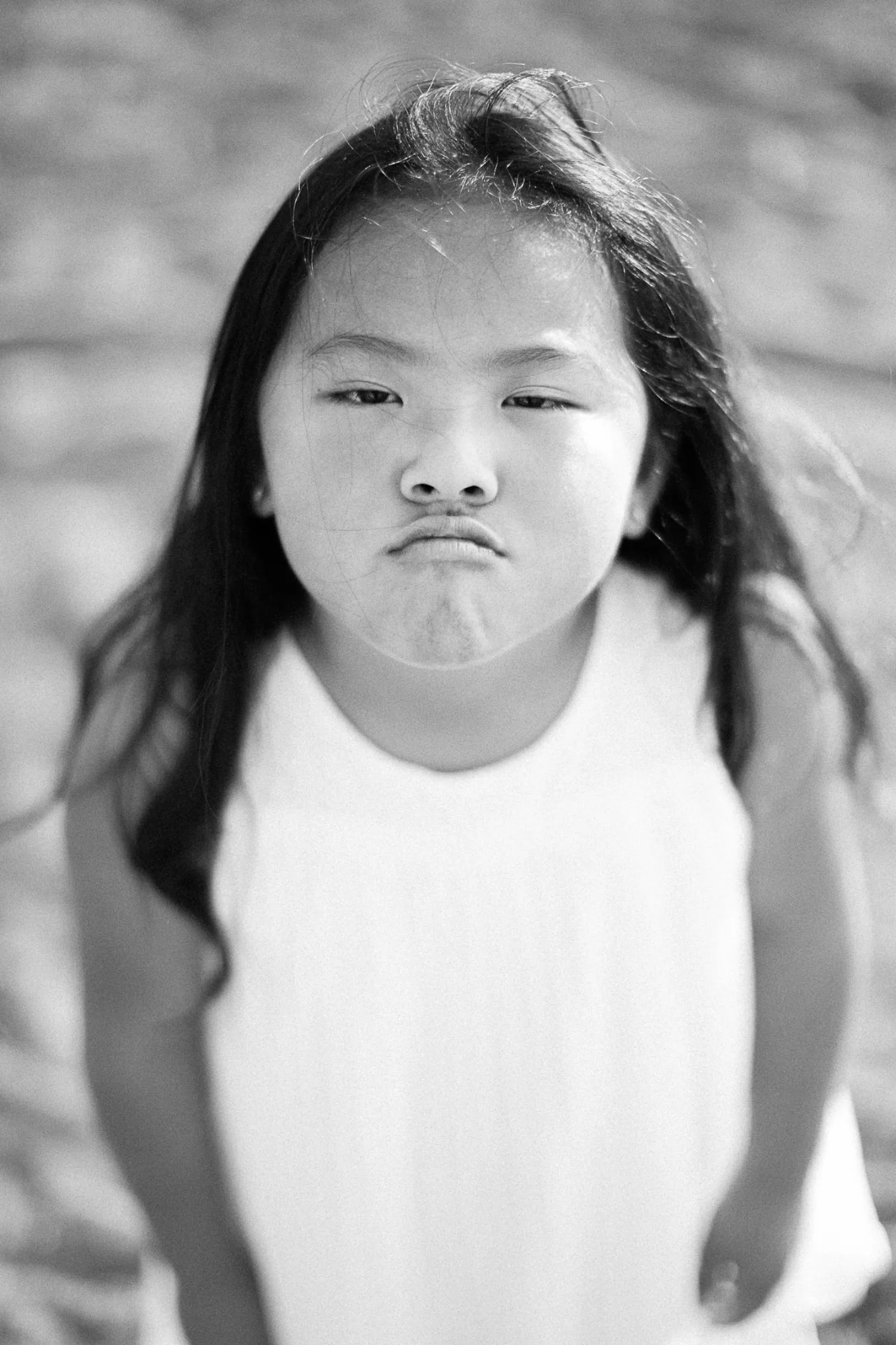 Black-and-white portrait of one of the sisters making a dramatic pout
