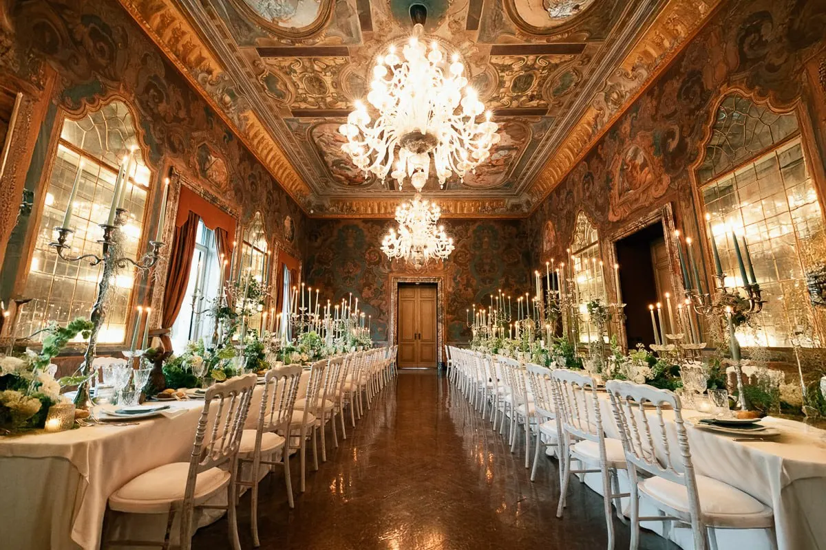 The reception hall at Villa Erba — frescoed ceilings, crystal chandeliers, candlelit tables lined with greenery