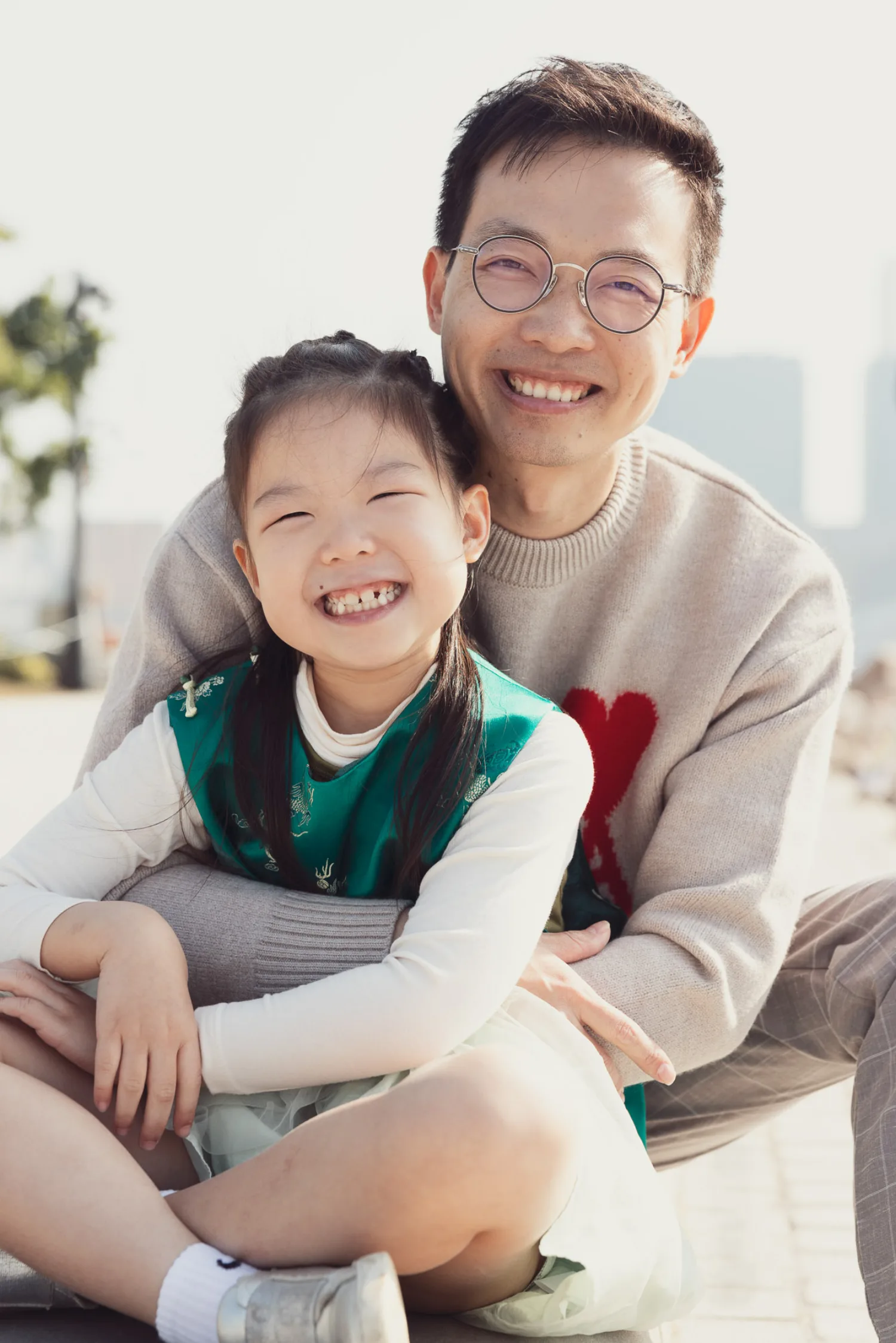 Vincent and Emma sharing a huge smile, faces close together — Vincent in his heart sweater, Emma in her green top