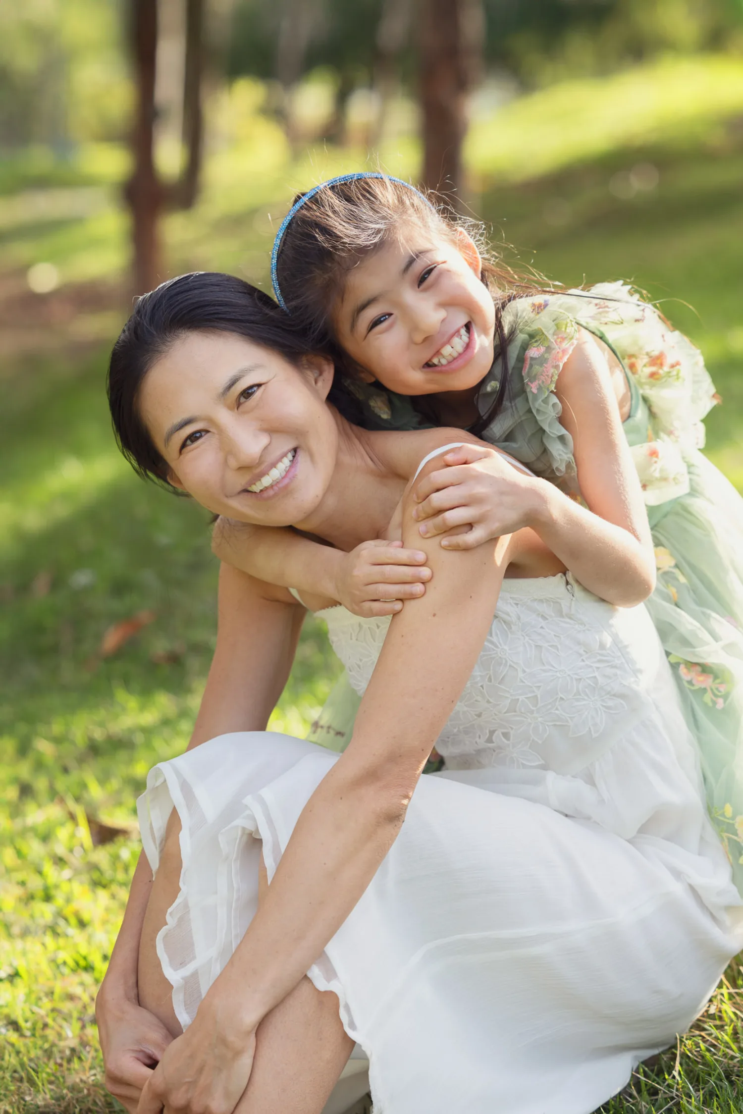 Sophie wrapping her arms around Suzanna in a joyful embrace on the grass