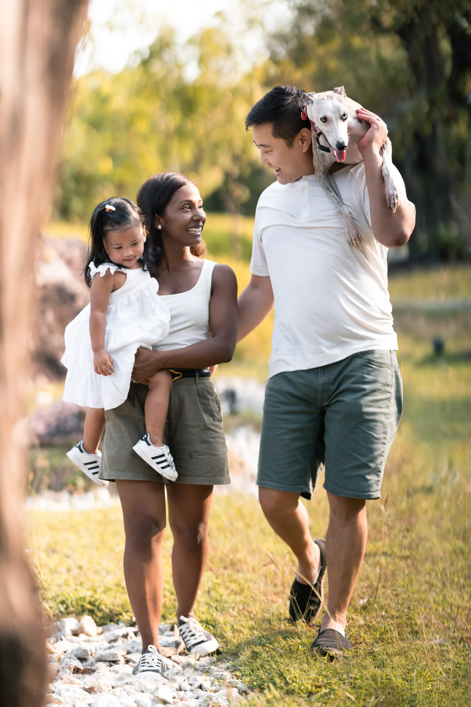 The family walking together — Dan carrying Luna over his shoulder, Jessica holding Gabby