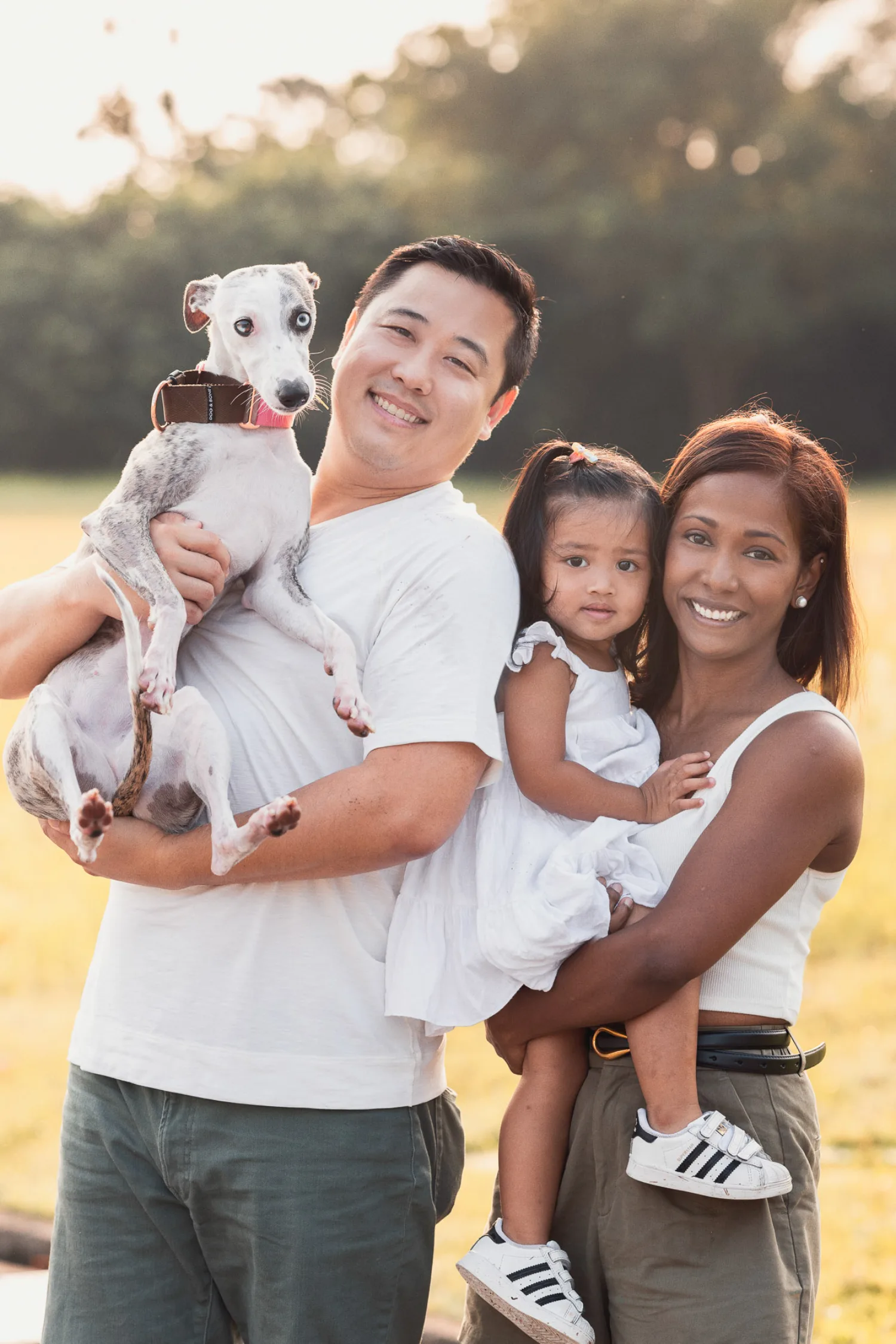 Dan, Jessica, Gabby, and Luna pose together as a family in golden hour light